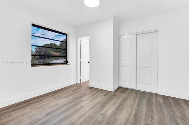 unfurnished bedroom with light hardwood / wood-style floors and a closet