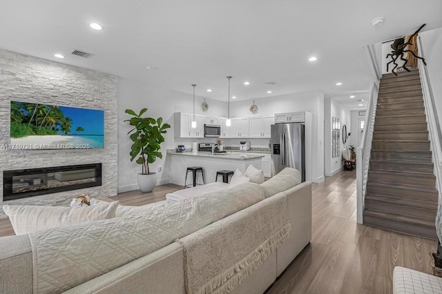 living room featuring light hardwood / wood-style flooring and a stone fireplace