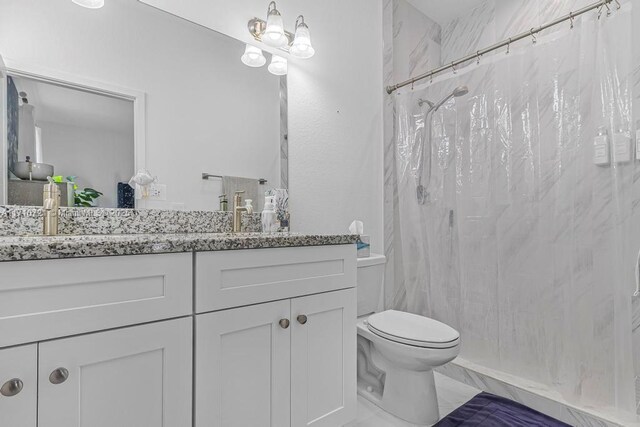 bathroom featuring toilet, vanity, and curtained shower