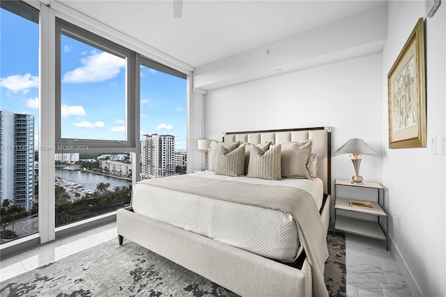 bedroom featuring ceiling fan and a water view