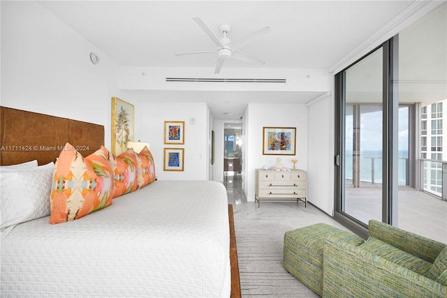 bedroom with ceiling fan, light hardwood / wood-style floors, access to exterior, and a wall of windows