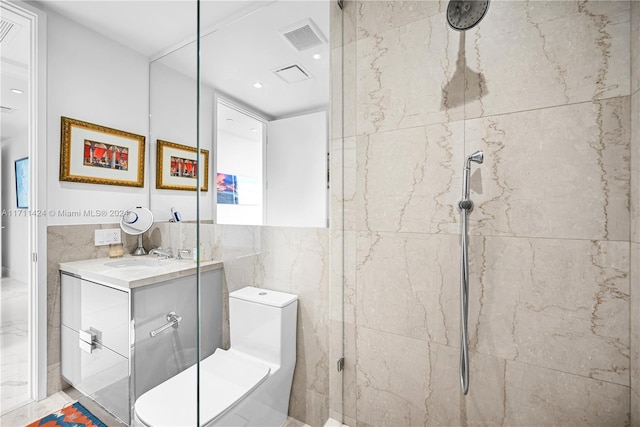 bathroom featuring tiled shower, vanity, tile walls, and toilet