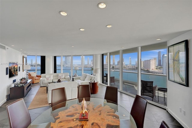 dining room featuring a water view, floor to ceiling windows, and light tile patterned flooring