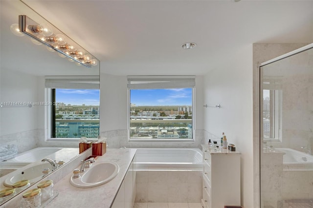 bathroom featuring plus walk in shower, vanity, and tile patterned flooring