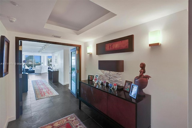 corridor featuring a tray ceiling