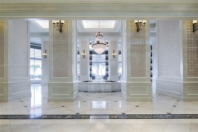 bathroom with decorative columns, crown molding, and an inviting chandelier