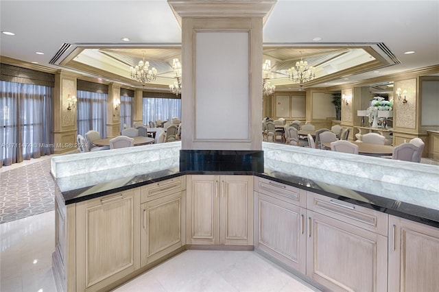 kitchen featuring a raised ceiling, crown molding, light brown cabinets, and an inviting chandelier