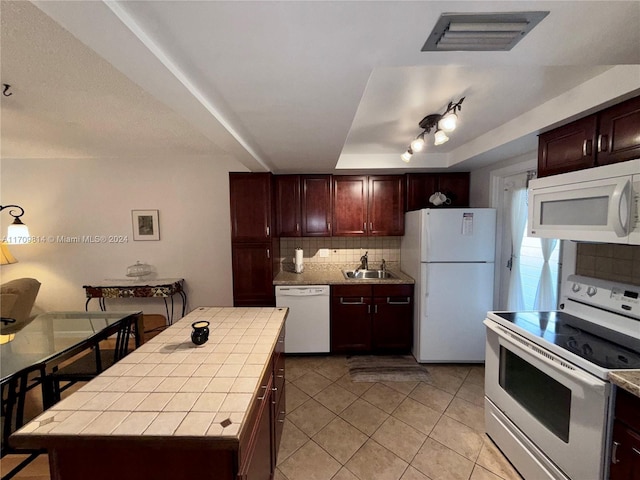 kitchen with tasteful backsplash, white appliances, sink, tile countertops, and a center island