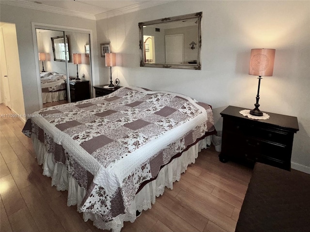 bedroom with crown molding, a closet, and wood-type flooring