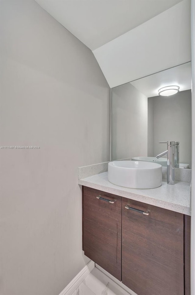 bathroom featuring vanity and lofted ceiling