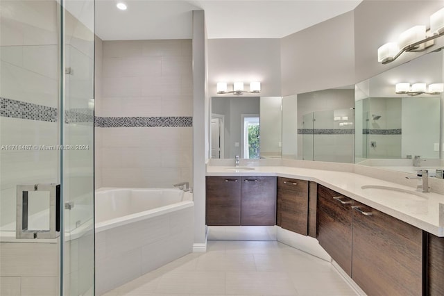 bathroom featuring tile patterned flooring, vanity, and shower with separate bathtub