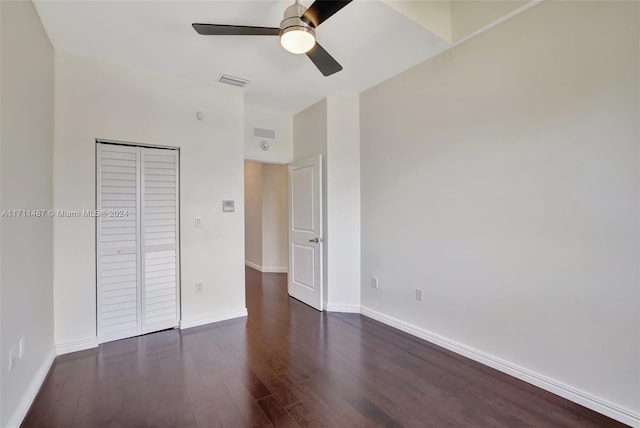 unfurnished bedroom featuring dark hardwood / wood-style floors, ceiling fan, and a closet