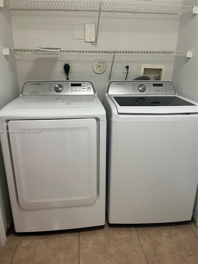 laundry area featuring washing machine and dryer and light tile patterned floors