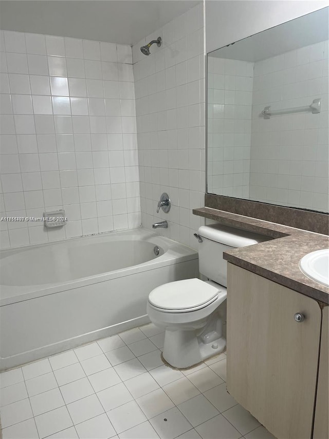 full bathroom featuring tile patterned flooring, vanity, tiled shower / bath combo, and toilet