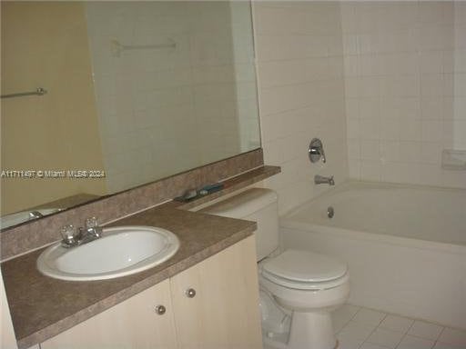 full bathroom featuring tile patterned flooring, vanity, toilet, and tiled shower / bath combo