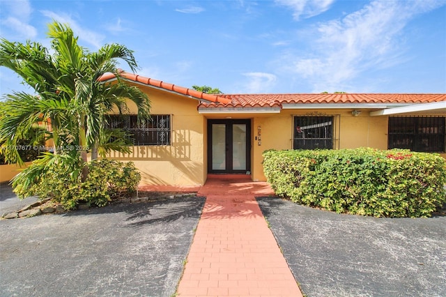 entrance to property with a tile roof and stucco siding