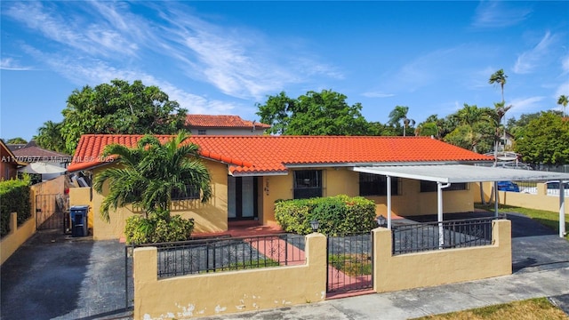 mediterranean / spanish home featuring stucco siding, a fenced front yard, a gate, and a tiled roof