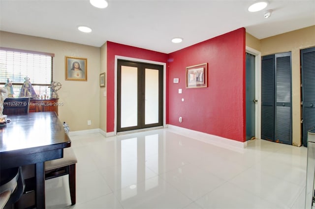 interior space featuring recessed lighting, baseboards, light tile patterned flooring, and french doors