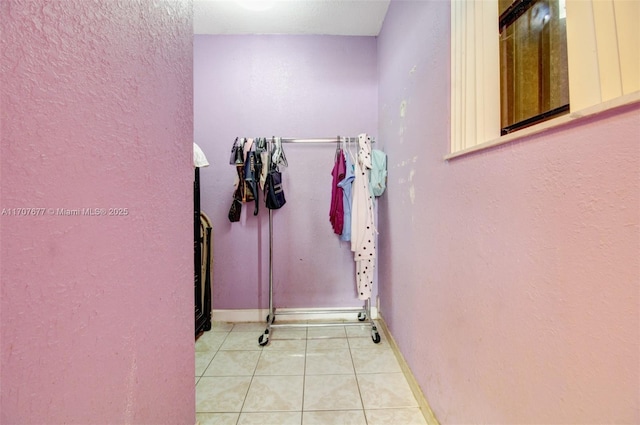 interior space with light tile patterned floors and baseboards