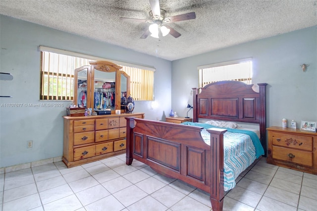 bedroom with light tile patterned flooring, ceiling fan, and a textured ceiling