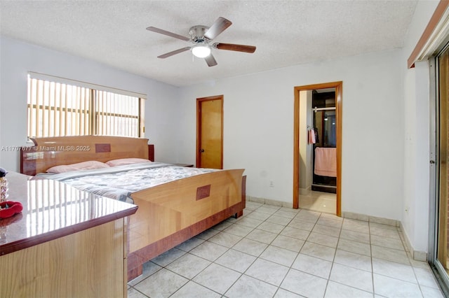 bedroom featuring light tile patterned floors, ceiling fan, a textured ceiling, and baseboards