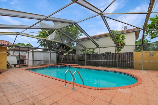 view of swimming pool featuring glass enclosure, a shed, a patio, and an outdoor structure