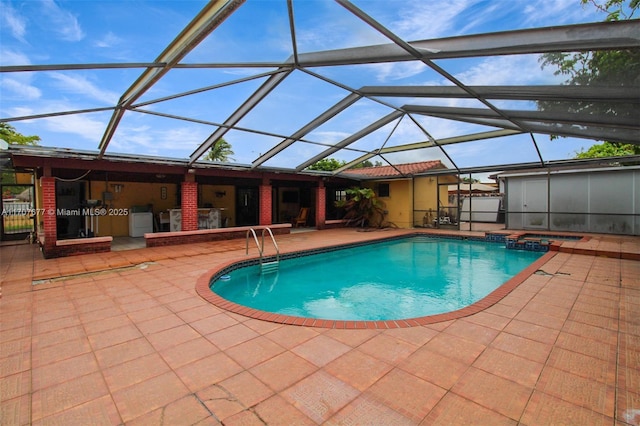 view of swimming pool with a lanai, a pool with connected hot tub, and a patio