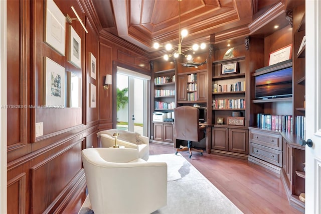 office space with built in features, light wood finished floors, ornamental molding, wooden walls, and coffered ceiling