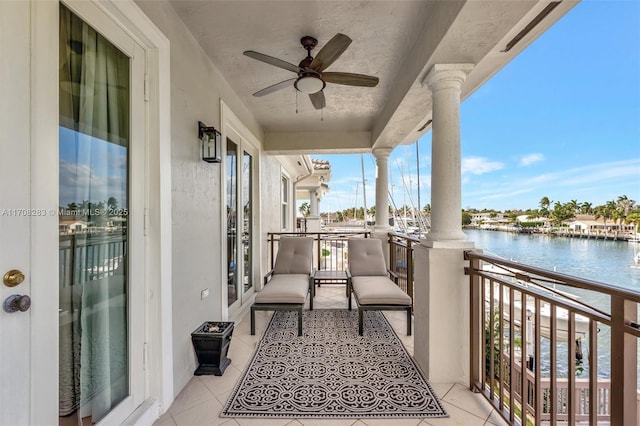 balcony featuring a water view and ceiling fan