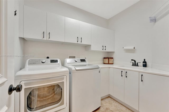 washroom with cabinets, sink, and washer and clothes dryer