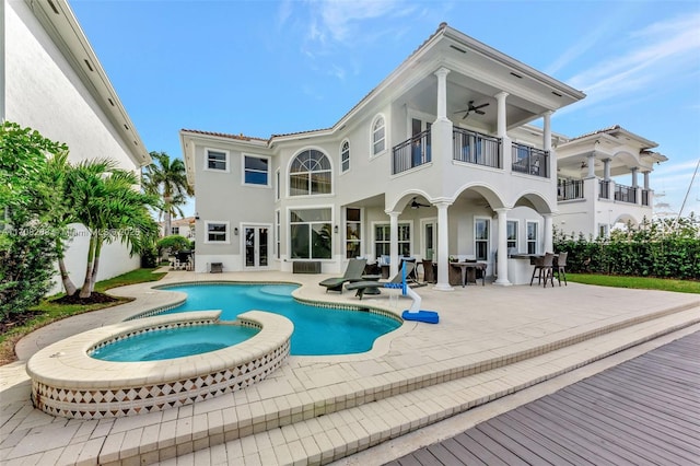 rear view of property with ceiling fan, a patio, a balcony, and stucco siding