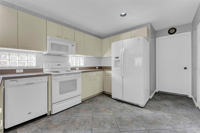 kitchen with cream cabinetry and white appliances