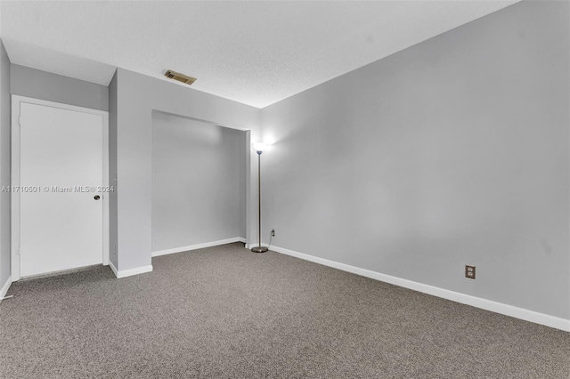 carpeted spare room with a textured ceiling