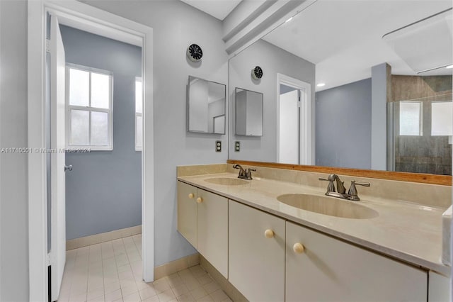 bathroom with tile patterned flooring, vanity, and a shower with door