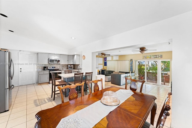 tiled dining room featuring vaulted ceiling, ceiling fan, and sink