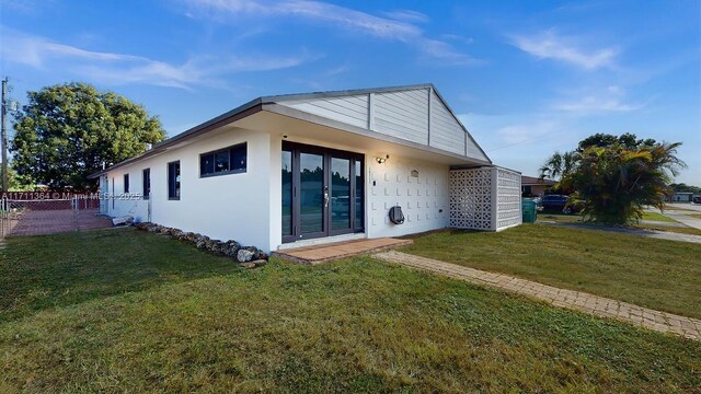 rear view of property featuring a lawn