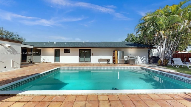 view of swimming pool featuring a patio area and grilling area