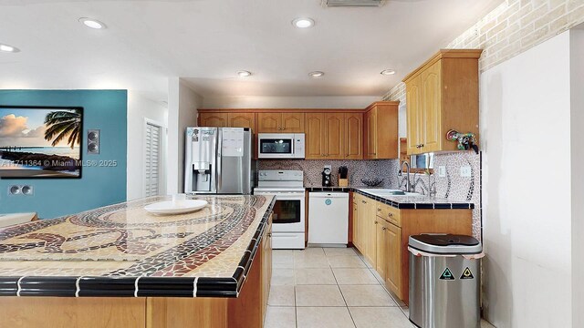 kitchen with white appliances, backsplash, sink, and tile countertops