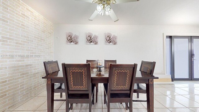 tiled dining space featuring brick wall