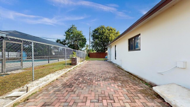 view of home's exterior with a lanai, a patio area, and a fenced in pool