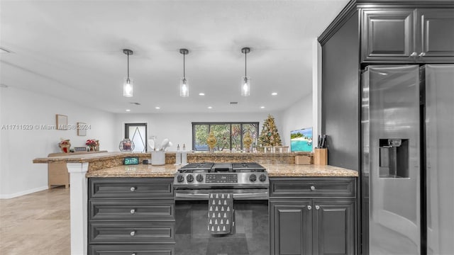 kitchen with light stone counters, kitchen peninsula, stainless steel appliances, and hanging light fixtures