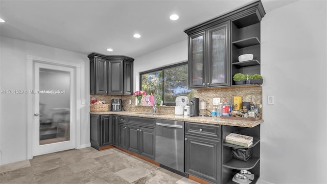 kitchen featuring dishwasher, light stone countertops, sink, and tasteful backsplash