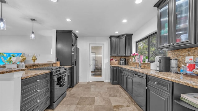 kitchen featuring decorative backsplash, light stone countertops, hanging light fixtures, and appliances with stainless steel finishes