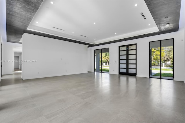 unfurnished room featuring a wealth of natural light and a tray ceiling