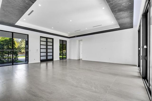 unfurnished room with french doors and a tray ceiling