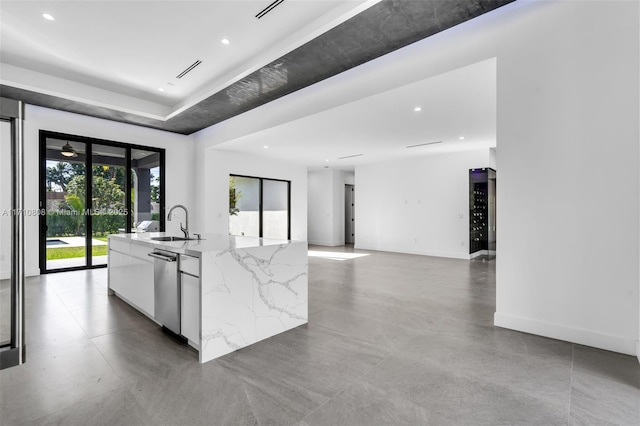 kitchen featuring white cabinetry, light stone countertops, sink, and stainless steel dishwasher