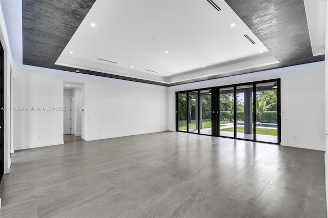 spare room with a raised ceiling and french doors