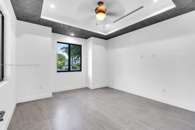 unfurnished room featuring ceiling fan and a tray ceiling