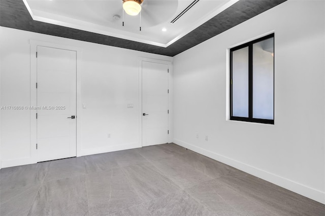 spare room with a tray ceiling