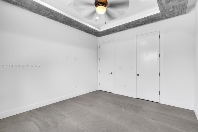 unfurnished bedroom with a raised ceiling and ceiling fan